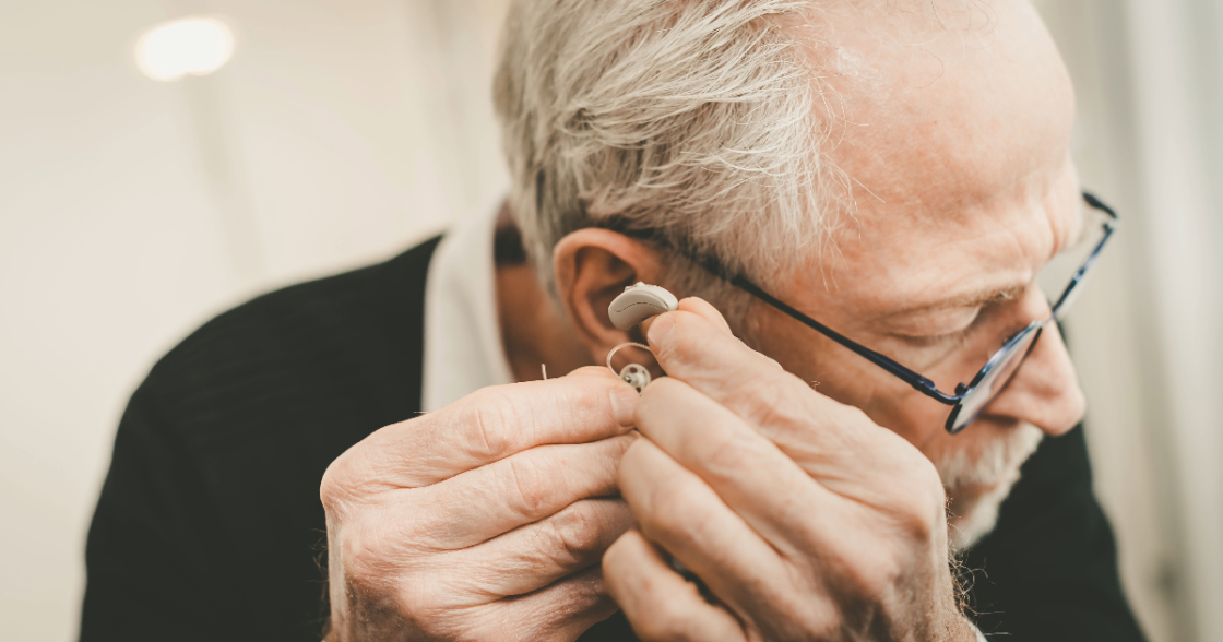 man putting on hearing aid